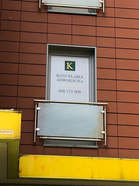 Tablica informacyjna kancelarii na elewacji
